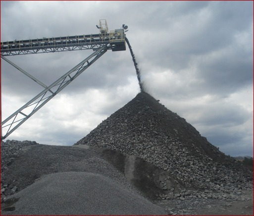 At the end of the conveyor belt, rock drops off into a pile, so that it can begin the process of being sifted through a series of screens. It falls through the screen holes to separate out larger pieces.