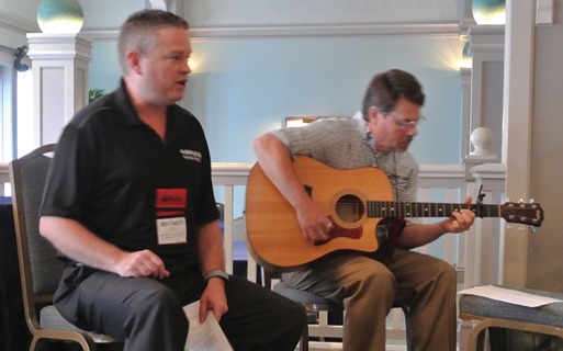 Greg Althammer (left) from Airplaco (MCAA Strategic Partner) performs a song during the MCAA Board Meeting with Jeff Leonard (right) from QUIKRETE (MCAA Strategic Partner) on guitar.