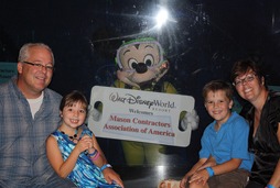 MCAA President and CEO Jeff Buczkiewicz (left) with daughter Logan, son Blake, wife Tami (right), and Mickey Mouse (center) during the MCAA Closing dinner at the Living Seas Salon at Epcot.
