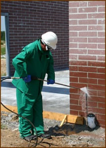 A technician cleans concrete brick. Note that the cleaning procedure for masonry starts at the bottom and works up. This is to keep rundown from soaking into, and staining dry masonry. Masonry below the area being cleaned always needs to be kept wet so that rundown won't soak in.